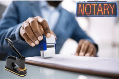 Person stamping a document with a notary sign and seal in view.