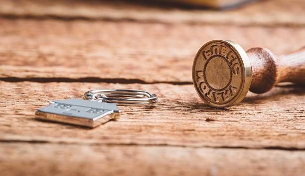 Notary stamp with house key chain placed on a table Notary stamp with house key chain placed on a table